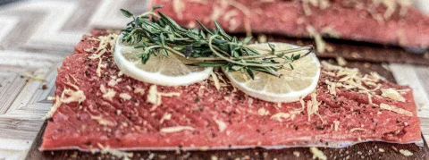 Roher Lachs mit Zitrone und Kräutern belegt